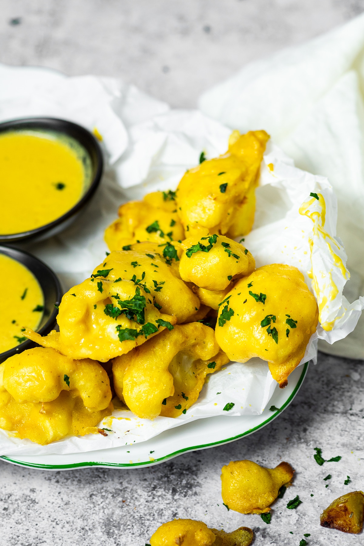 Bird View on a serving plate with honey mustard cauliflower wings and with two dipping bowls.