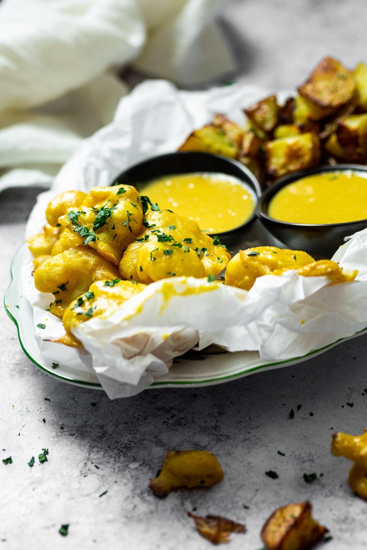 Bird View on a serving plate with honey mustard cauliflower wings and roasted potatoes with two dipping bowls.