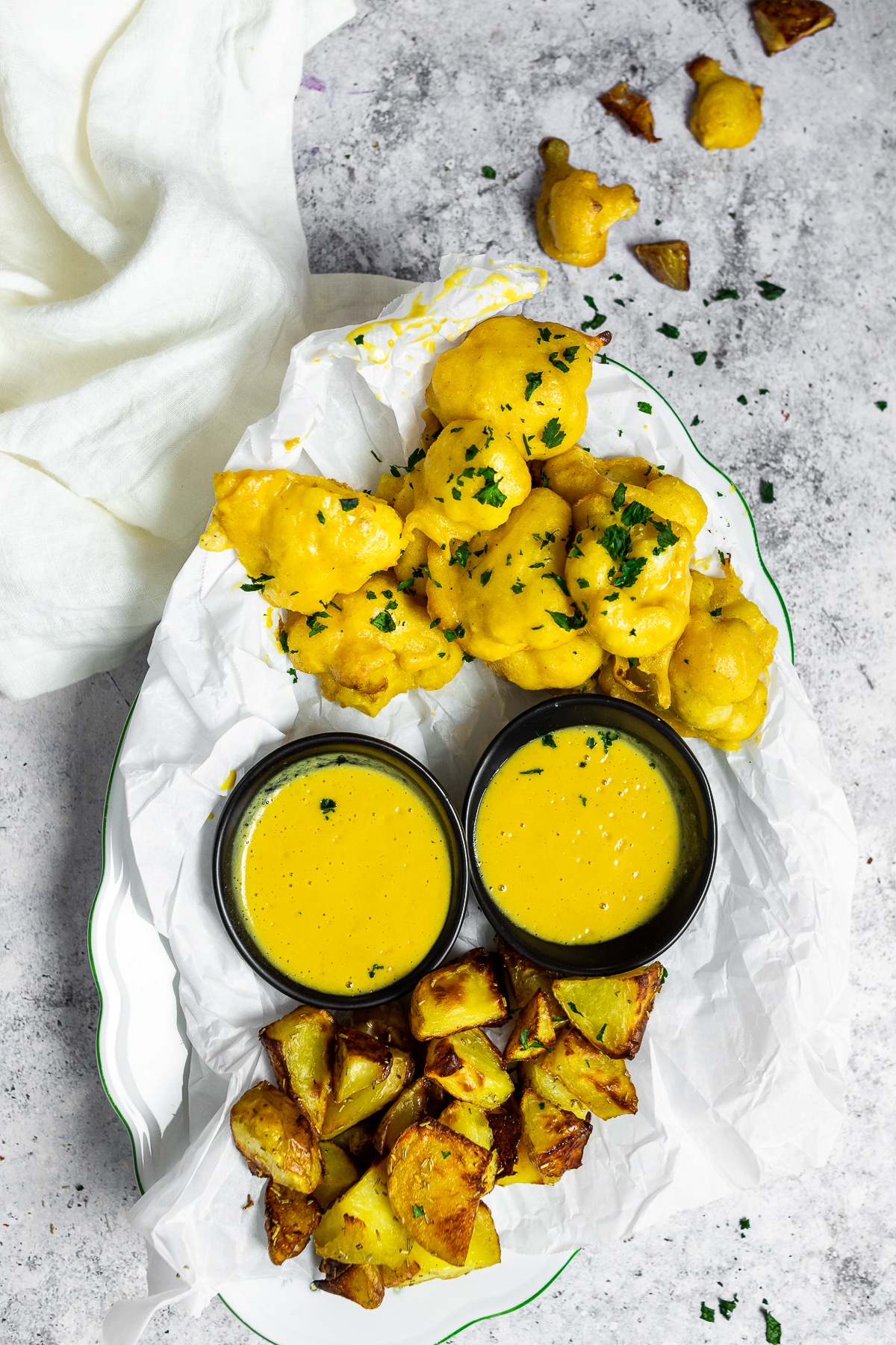 Bird View on a serving plate with honey mustard cauliflower wings and tofu wings with two dipping bowls.