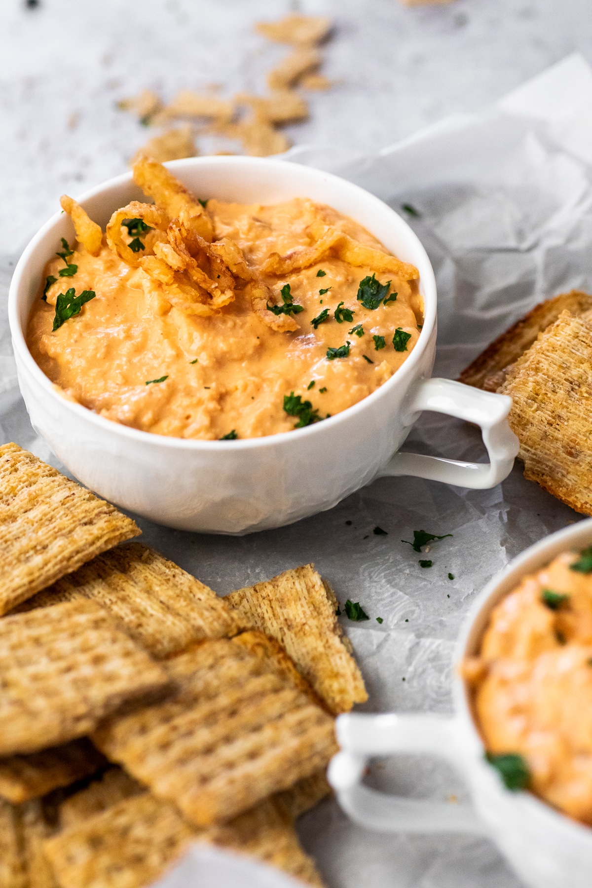 Onion Dip in a cup in focus with a half blurred on the side