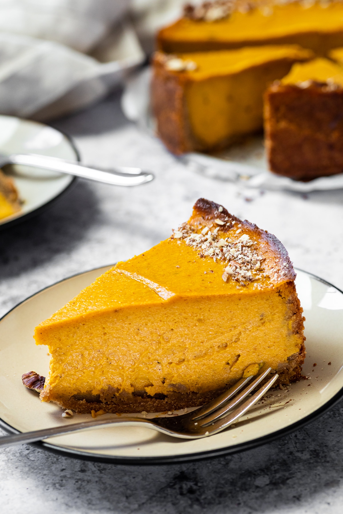 One Cheesecake with Pumpkin on a plate with the cheesecake in the background