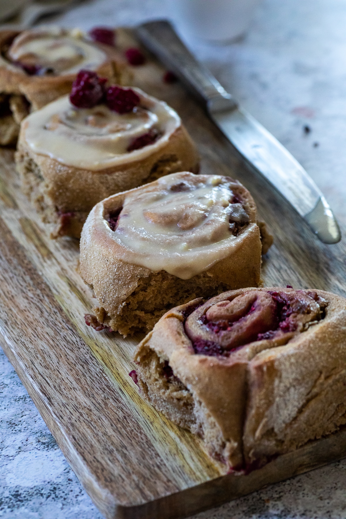 4 Raspberry Buns served on a wooden board.