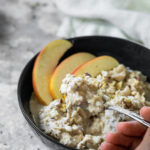 Bircher Muesli served in a bowl and some of the overnight oats on a spoon.