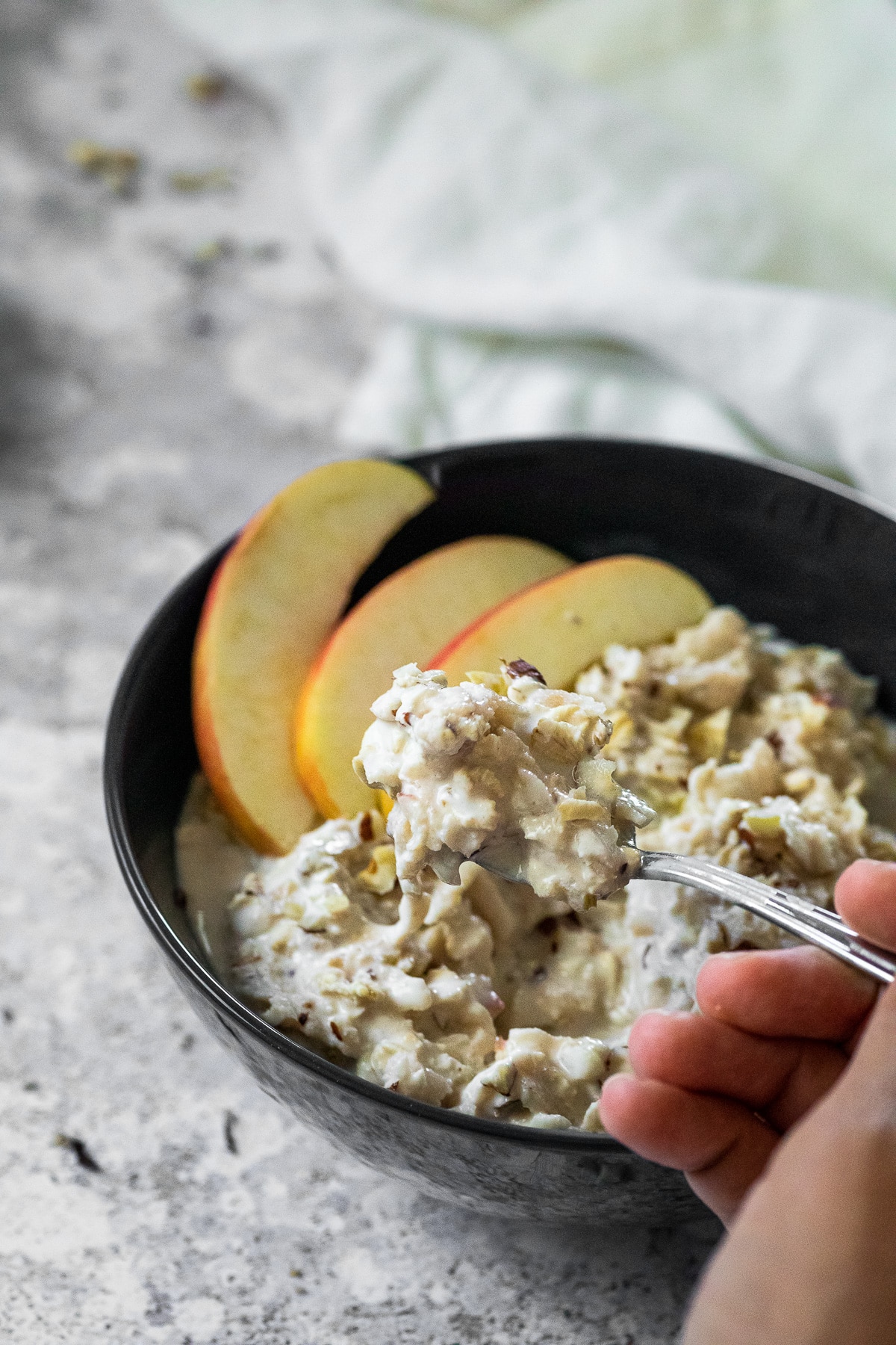 Bircher Muesli served in a bowl and some of the overnight oats on a spoon.