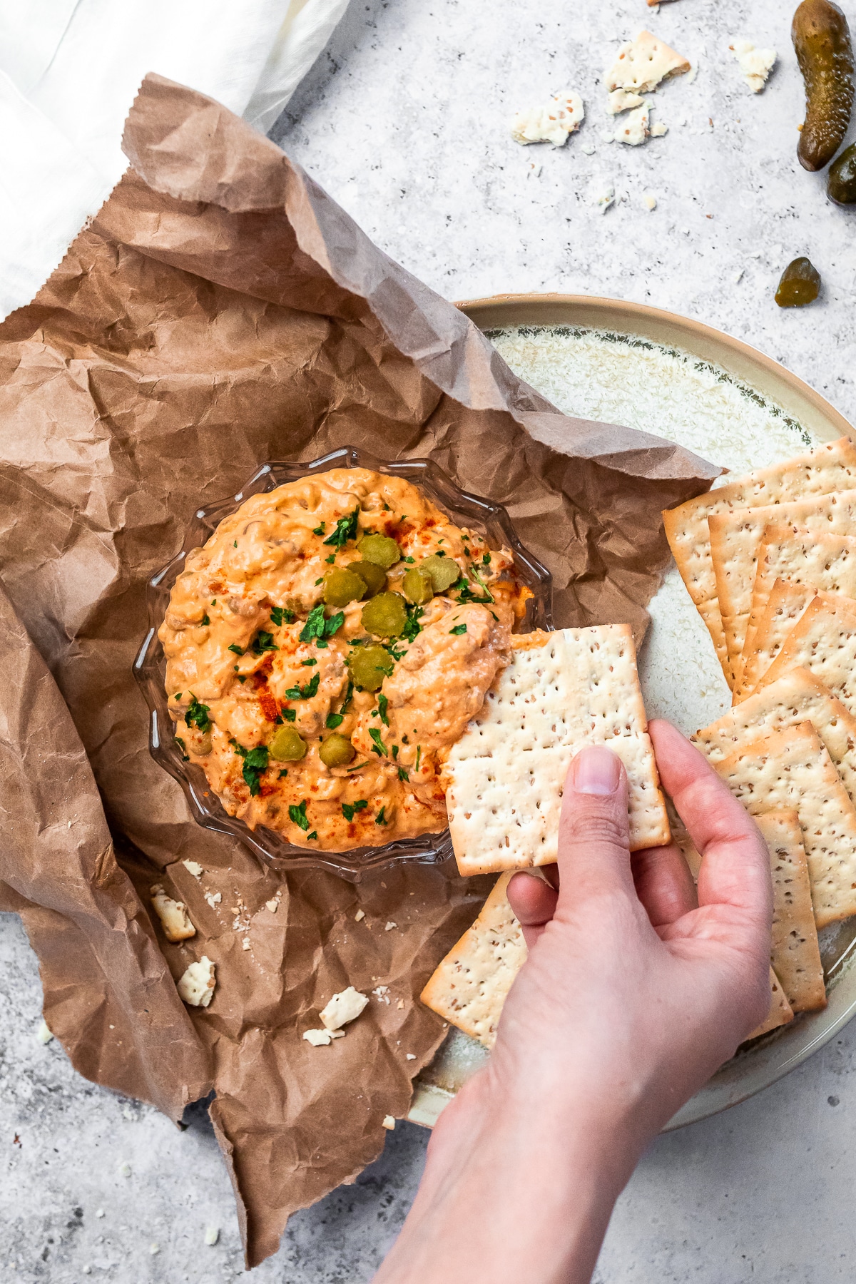 Dipping a cracker in the bowl of cheeseburger dip