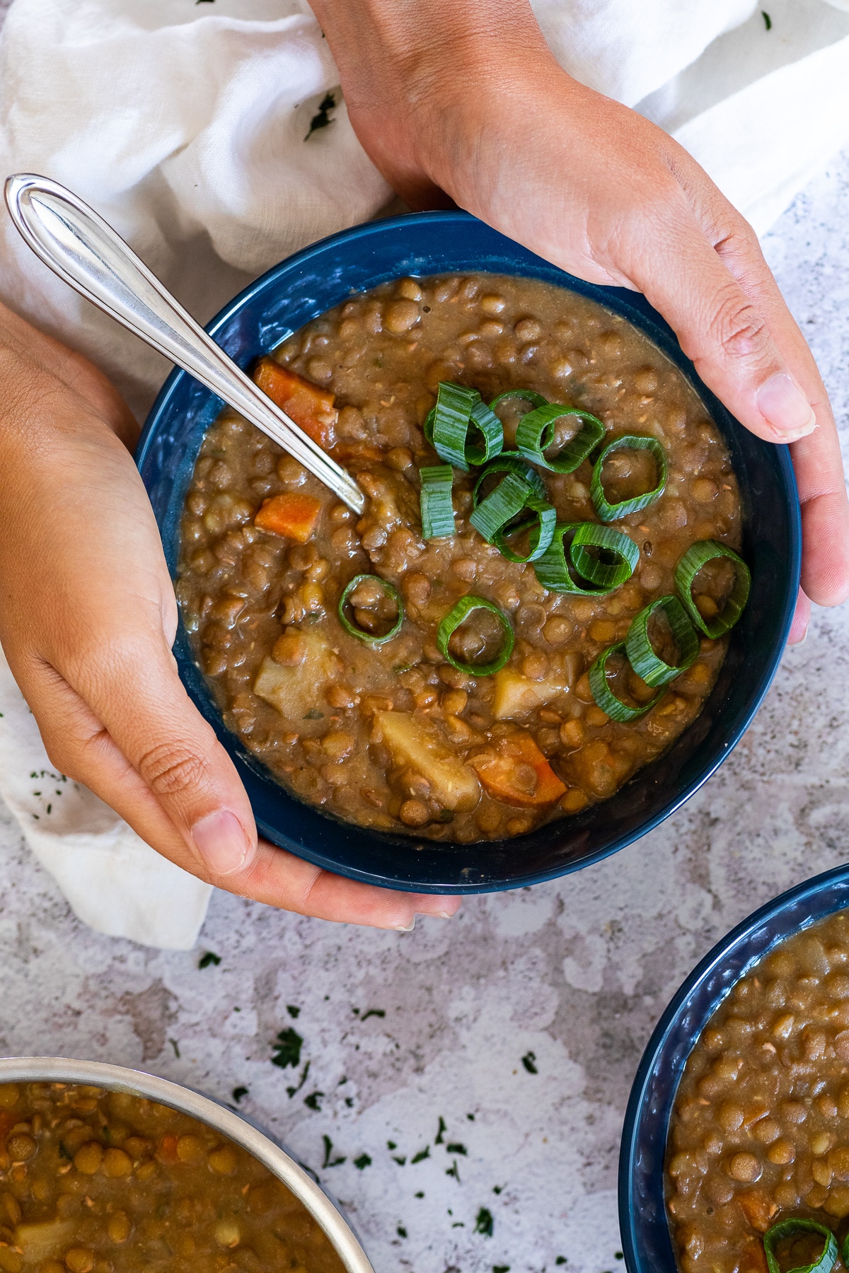 Holding a bowl of lentil soup