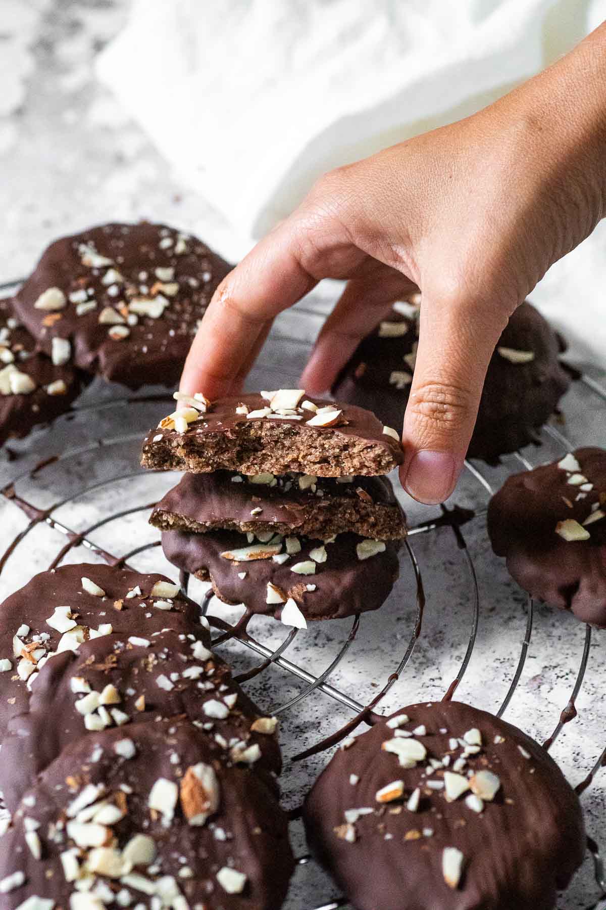 Halten eines halb veganen Lebkuchenplätzchens, das auf anderen deutschen Lebkuchen auf einem Drahtwrack gestapelt ist.