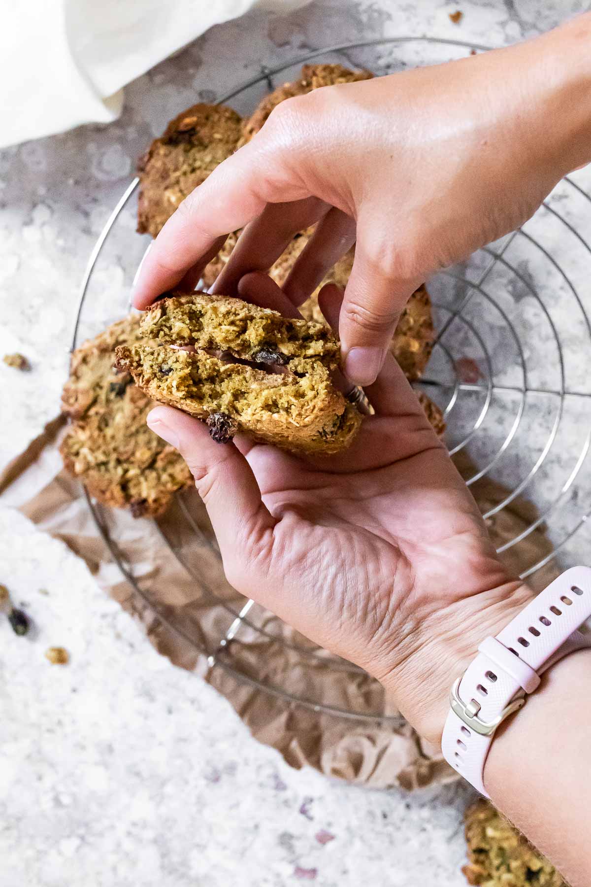 Halten Sie zwei Hälften des veganen Haferkekses in der Hand.