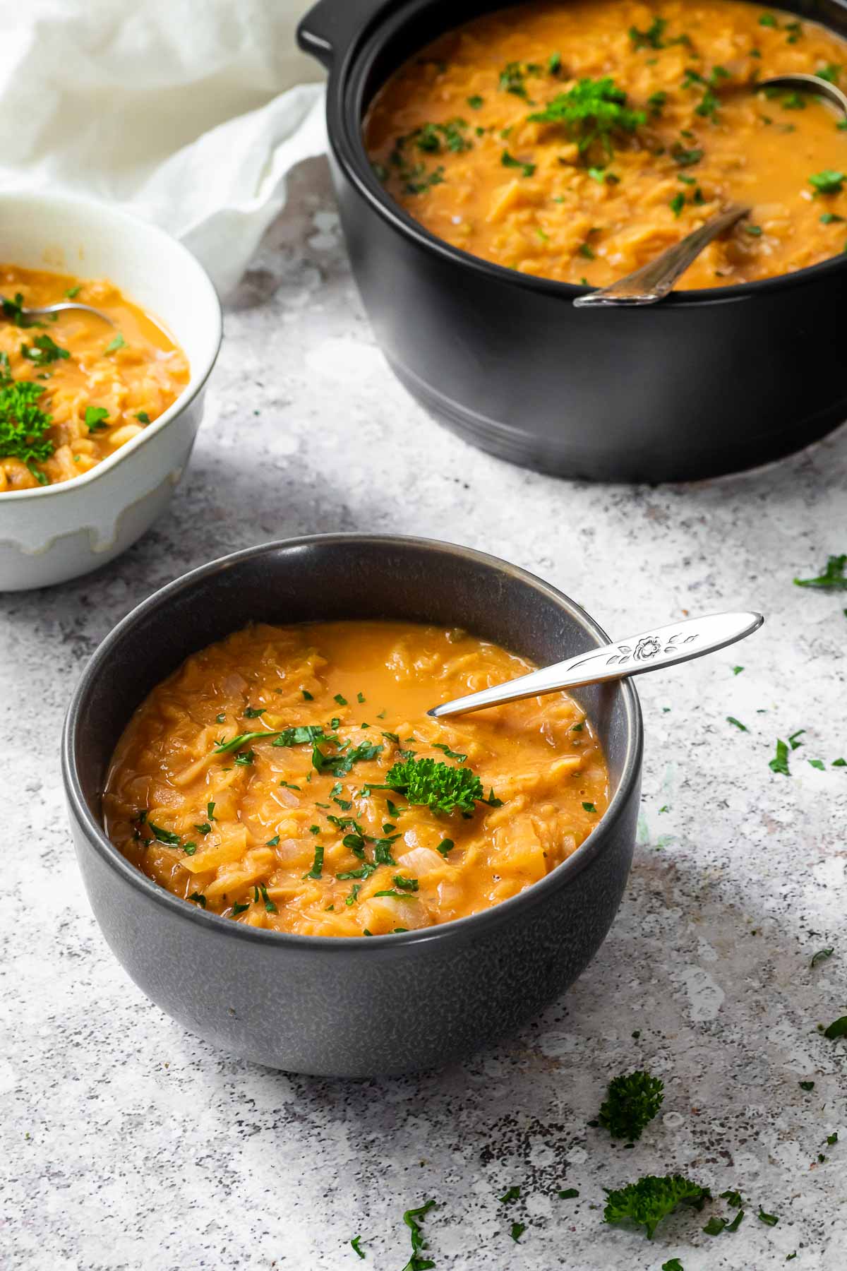 2 Schalen mit Sauerkrautsuppe und ein Topf voll Sauerkrautsuppe