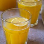 2 cups with warm winter lemonade with a lemon slice on top.