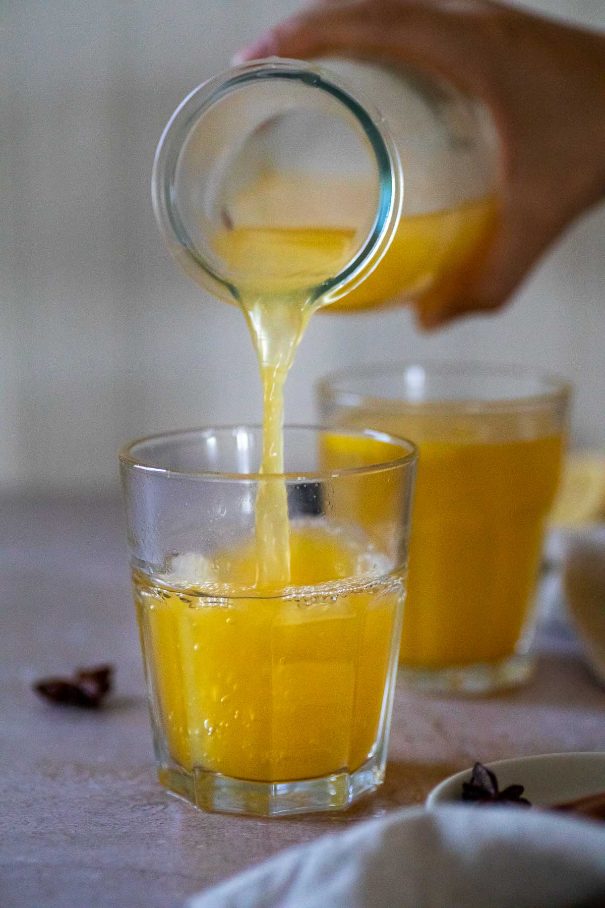 Pouring some warm winter lemonade in a cup.