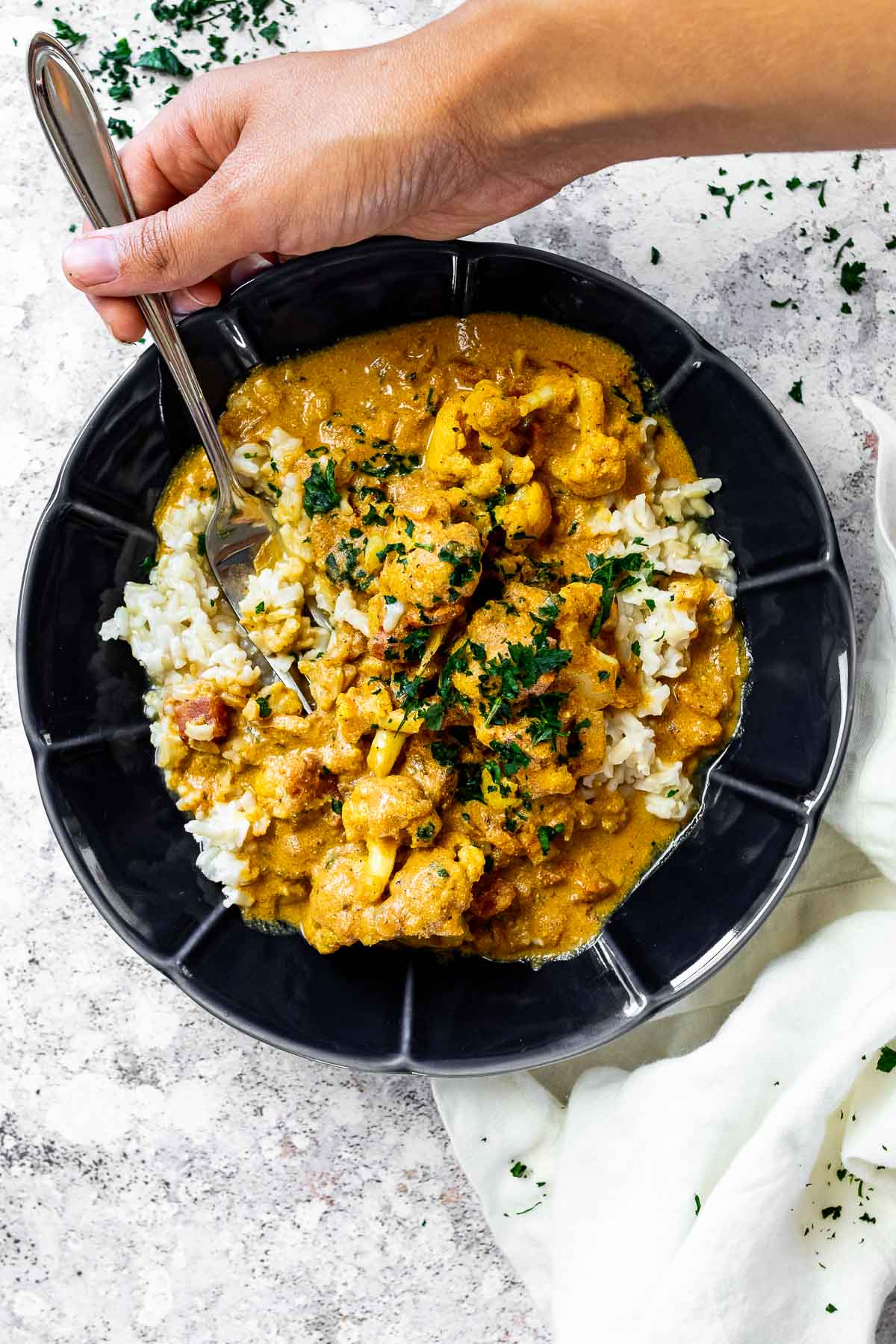 Halten einer Gabel in einer Schüssel mit veganem Butterblumenkohl auf pflanzlicher Basis