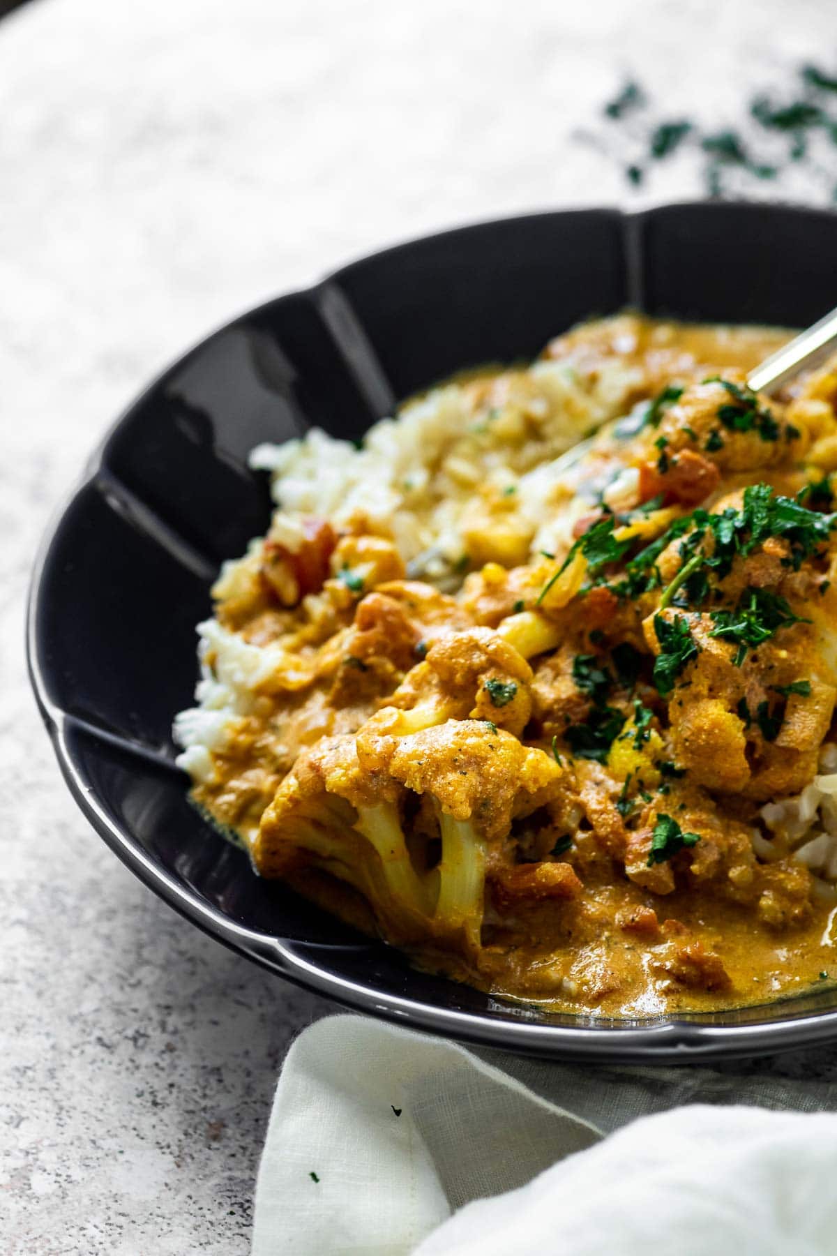 Close up of a cauliflower smoothered in vegan butter sauce