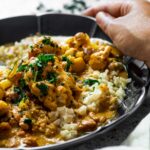 Halten Sie die Schüssel mit veganem Butterhuhn mit Reis. Nahansicht