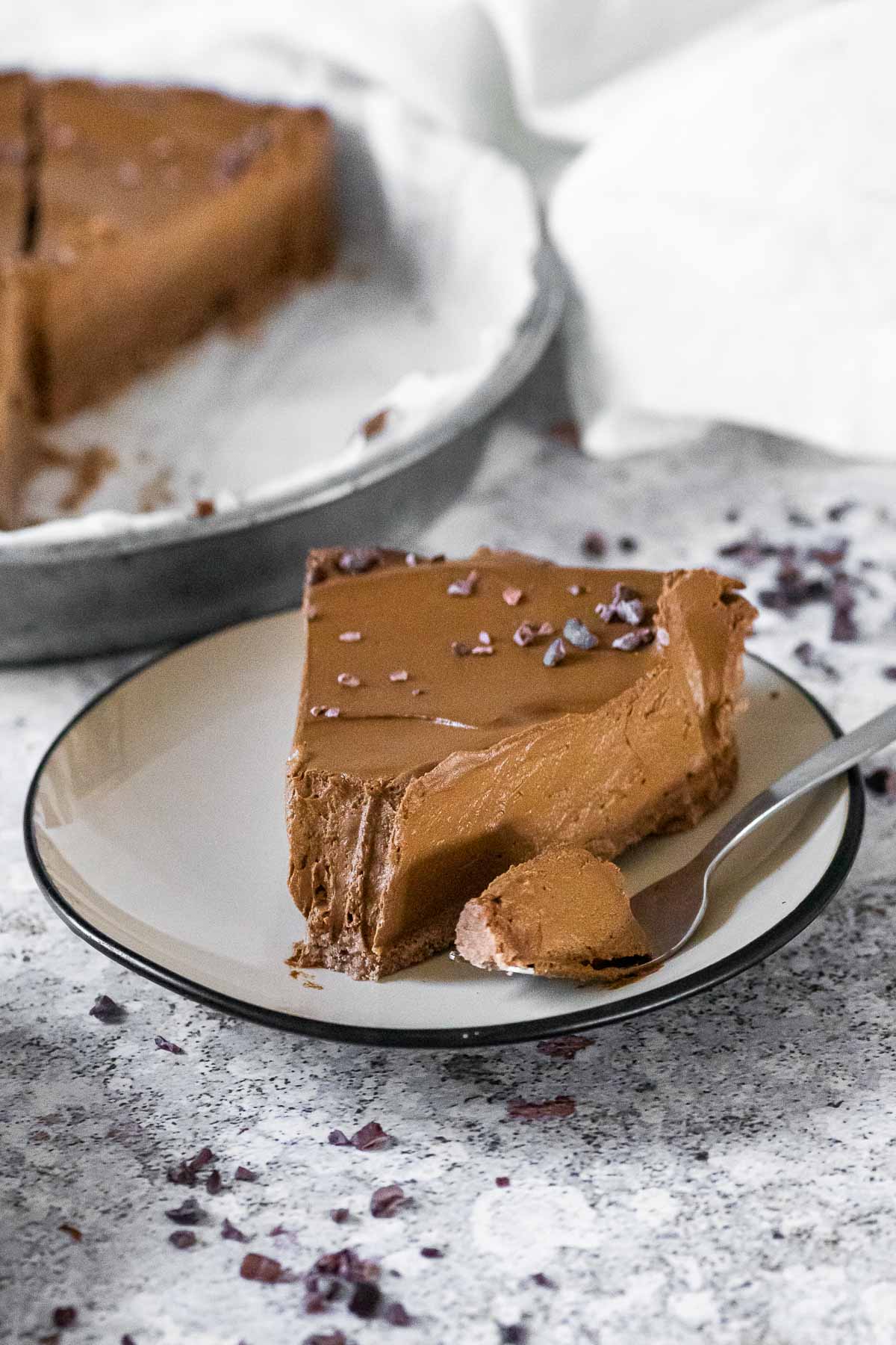 Close up of one dairy free chocolate pie on a plate with some pie on a fork.