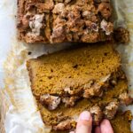 Ein Stück veganes Kürbisbrot greifen
