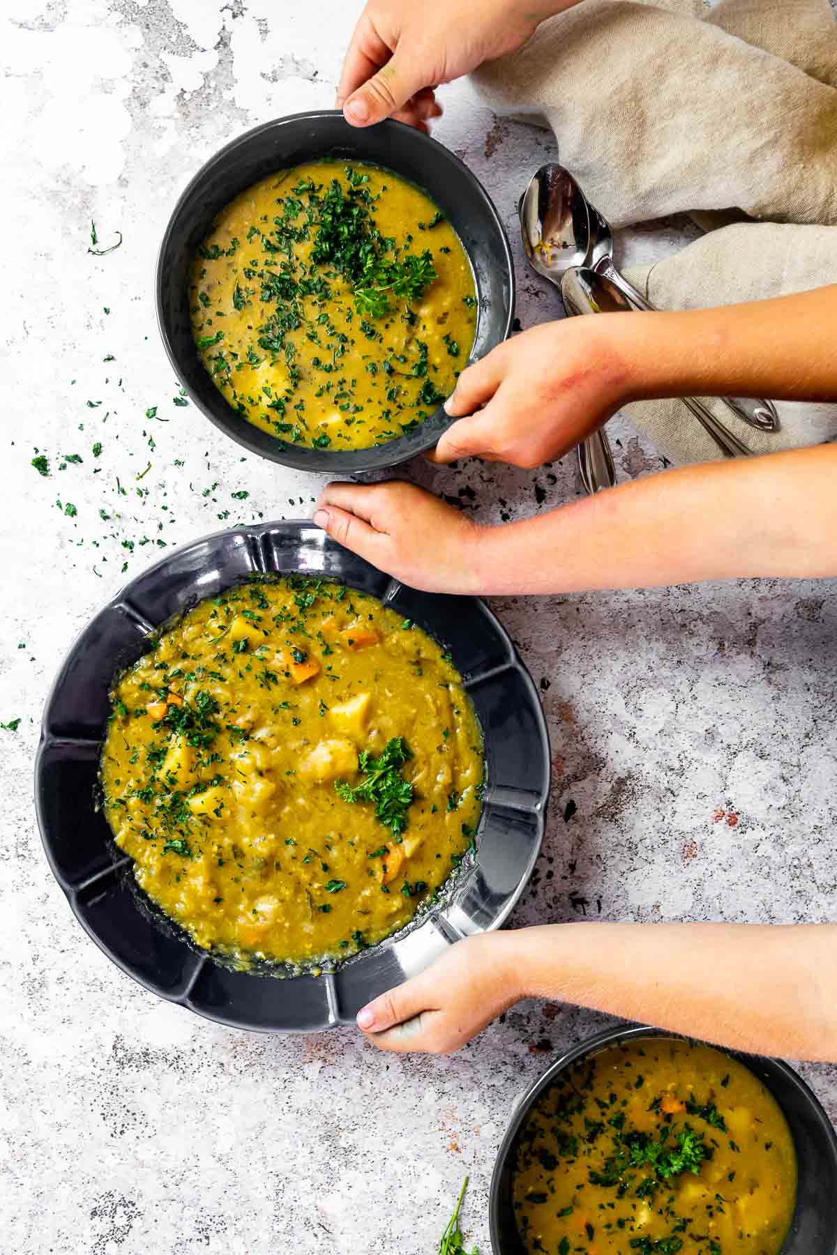 Holding 2 bowls of vegan split pea soup