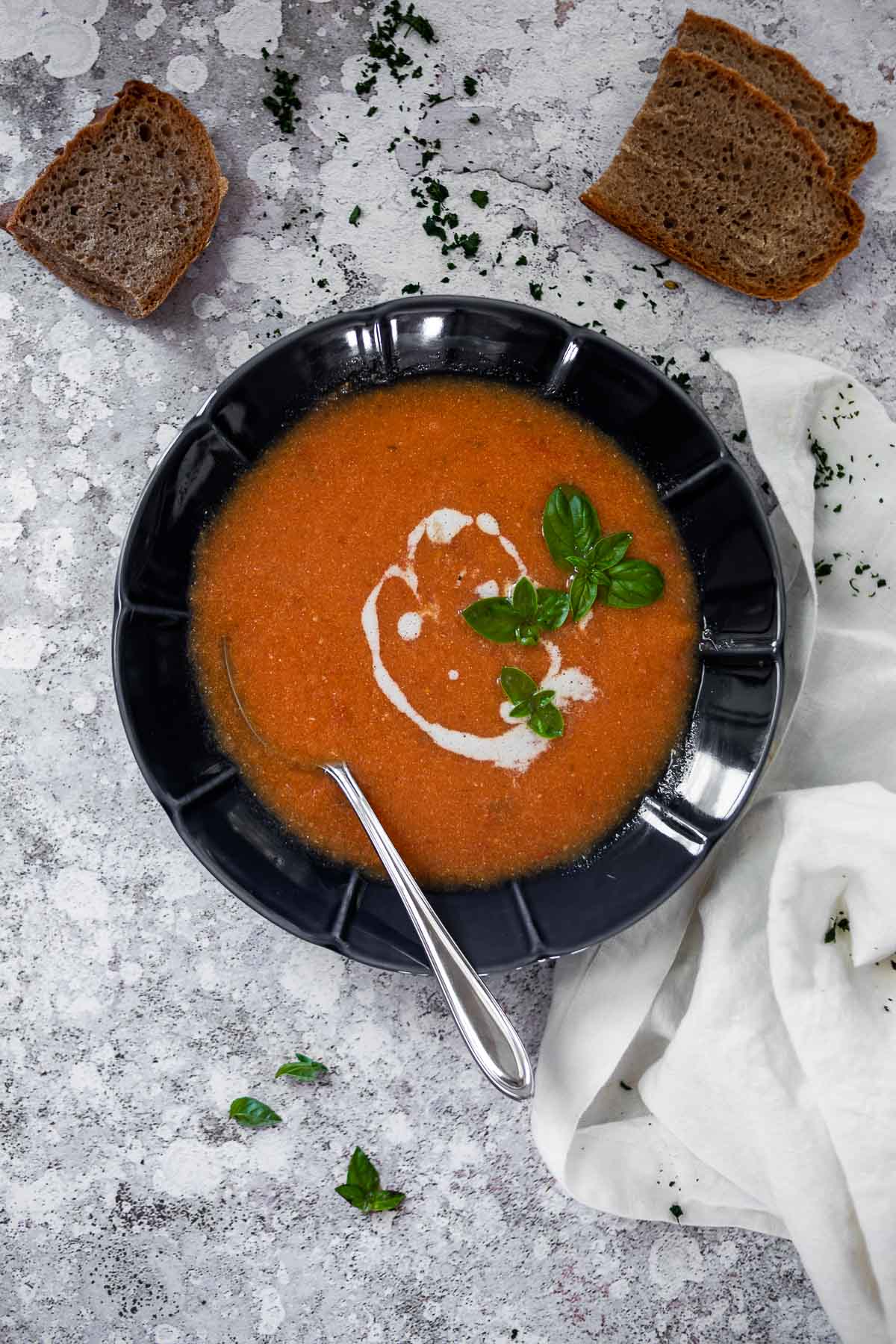 Vogelansicht einer Schüssel mit Tomatensuppe und Brot