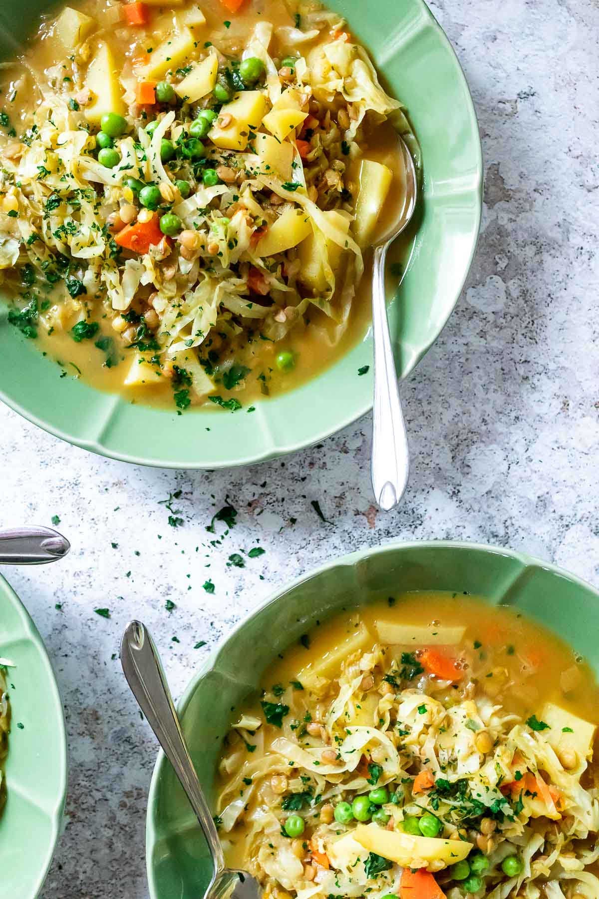 Zwei Schalen mit veganem Kohllinseneintopf.