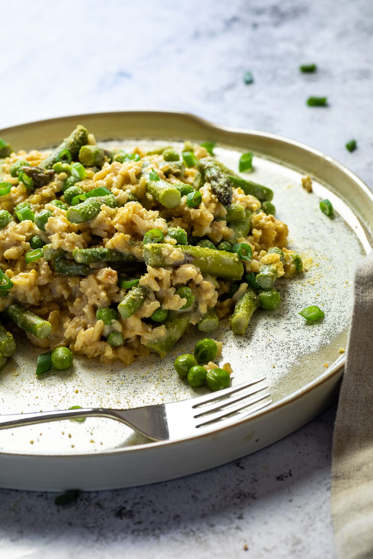 Nahaufnahme von veganem Erbsen- und Spargelrisotto auf einem Teller