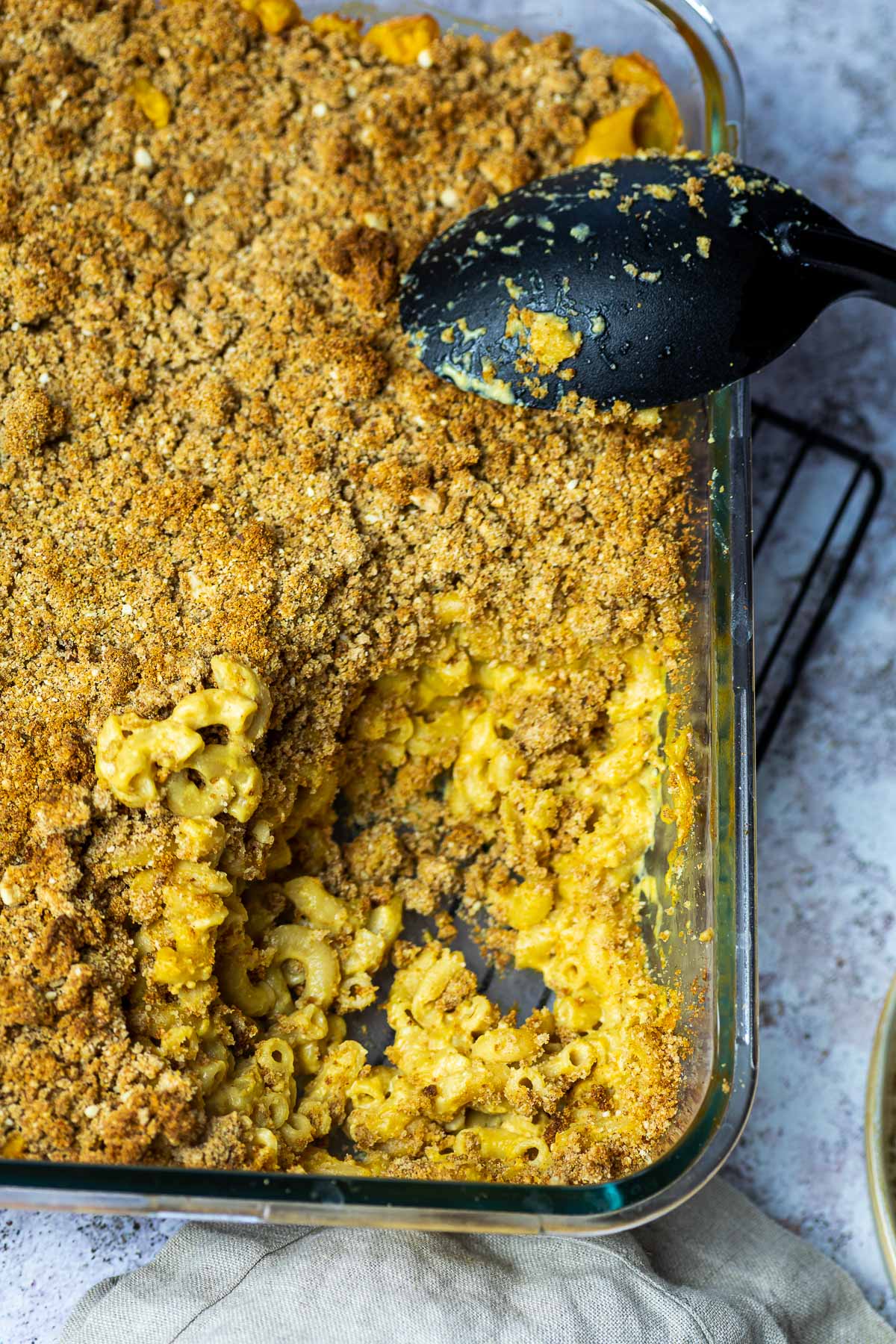 Dairy free Baked Mac and Cheese in a casserole topped with homemade bread crumbs.