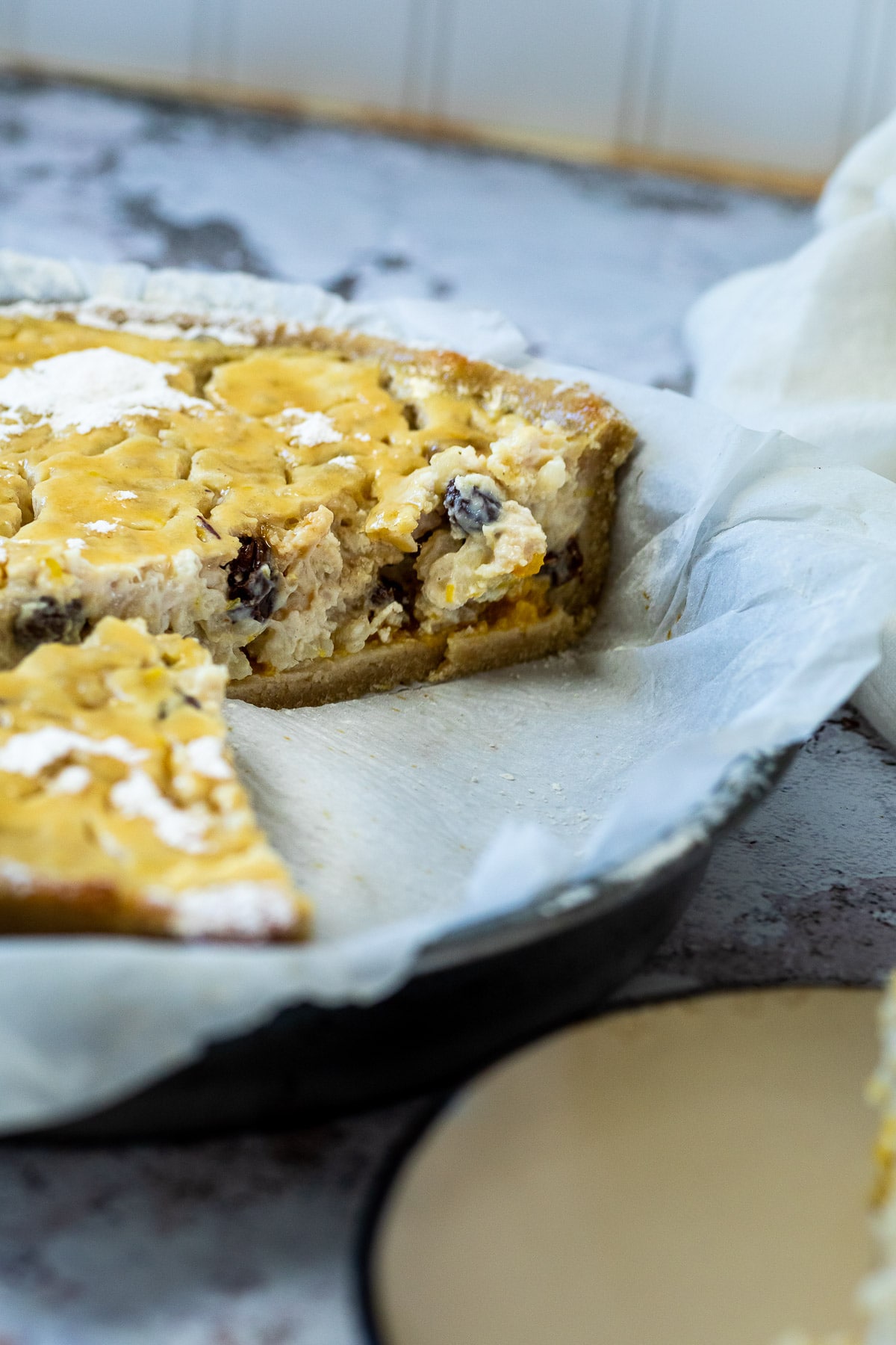 Millchreiskuchen in einer Kuchenform mit einigen fehlenden Stücken. Die Kuchenfüllung ist fokussiert.