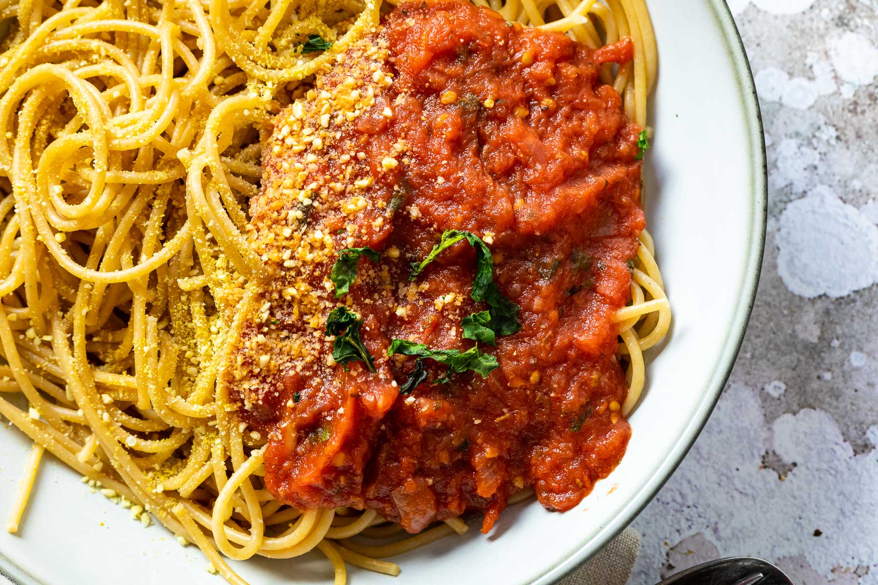 Nahaufnahme von oben von einer Schüssel mit Spaghetti und Marinara-Sauce.