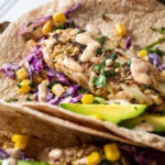 Ein veganer Fischstäbchen im Fokus wird in einem veganen Taco serviert.