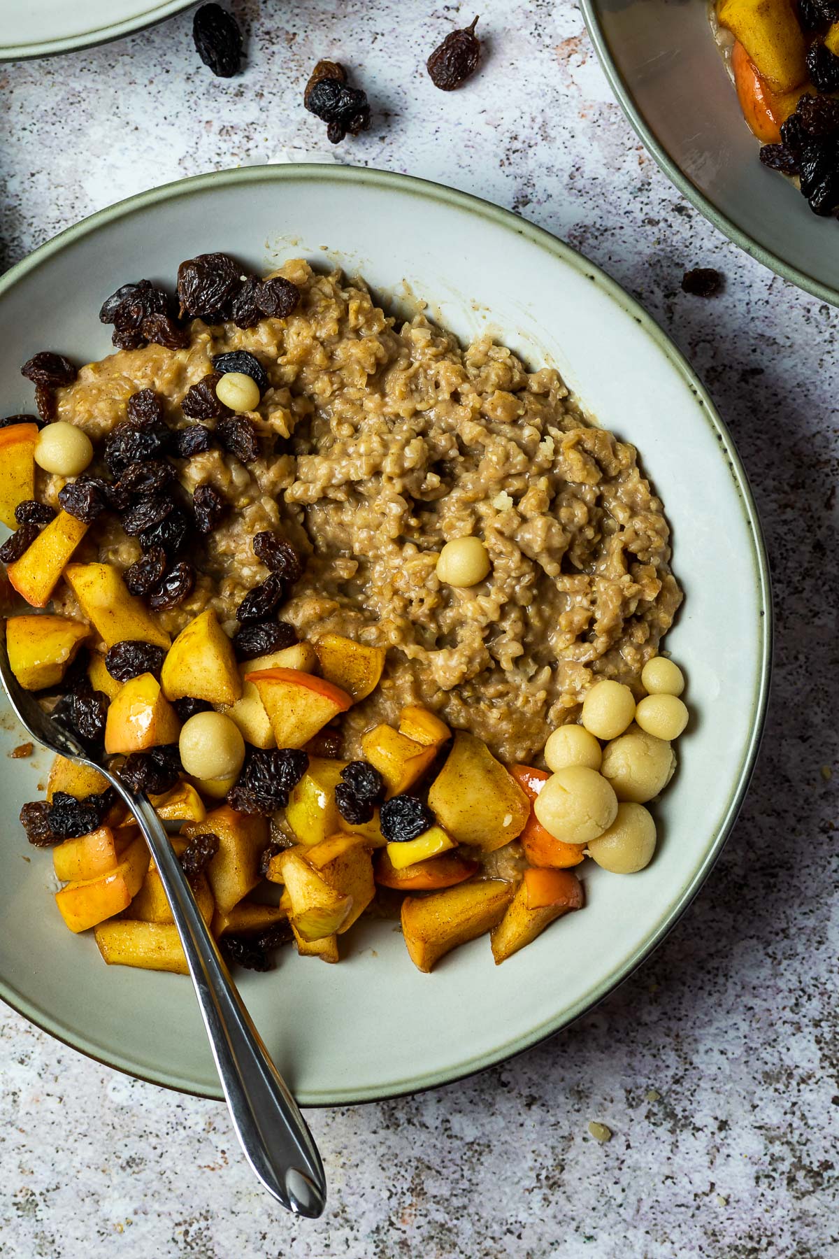 One plate with oatmeal baked apples, marzipan and a spoon