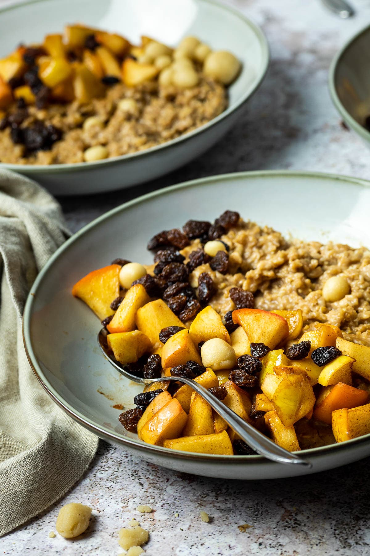 One bowl with a spoon of baked apple oatmeal and marzipan