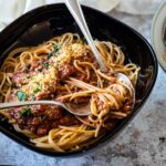 Eine Schüssel mit veganem Bolognese und Spaghetti im Fokus