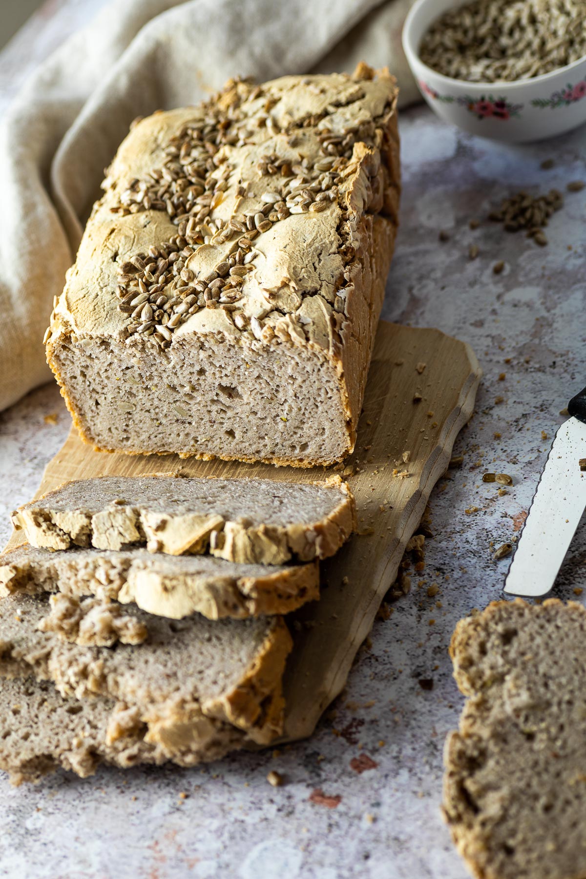 Buchweizenbrot serviert auf einem Holzbrett mit einigen Scheiben