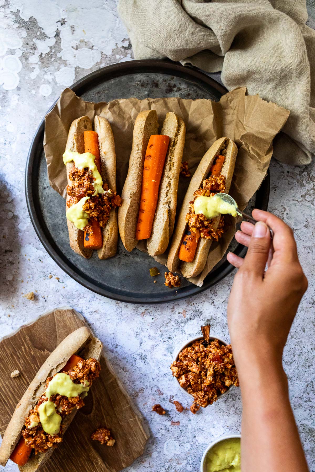 Gebe etwas vegane Queso-Sauce auf die veganen Chili-Käse-Hot-Dog