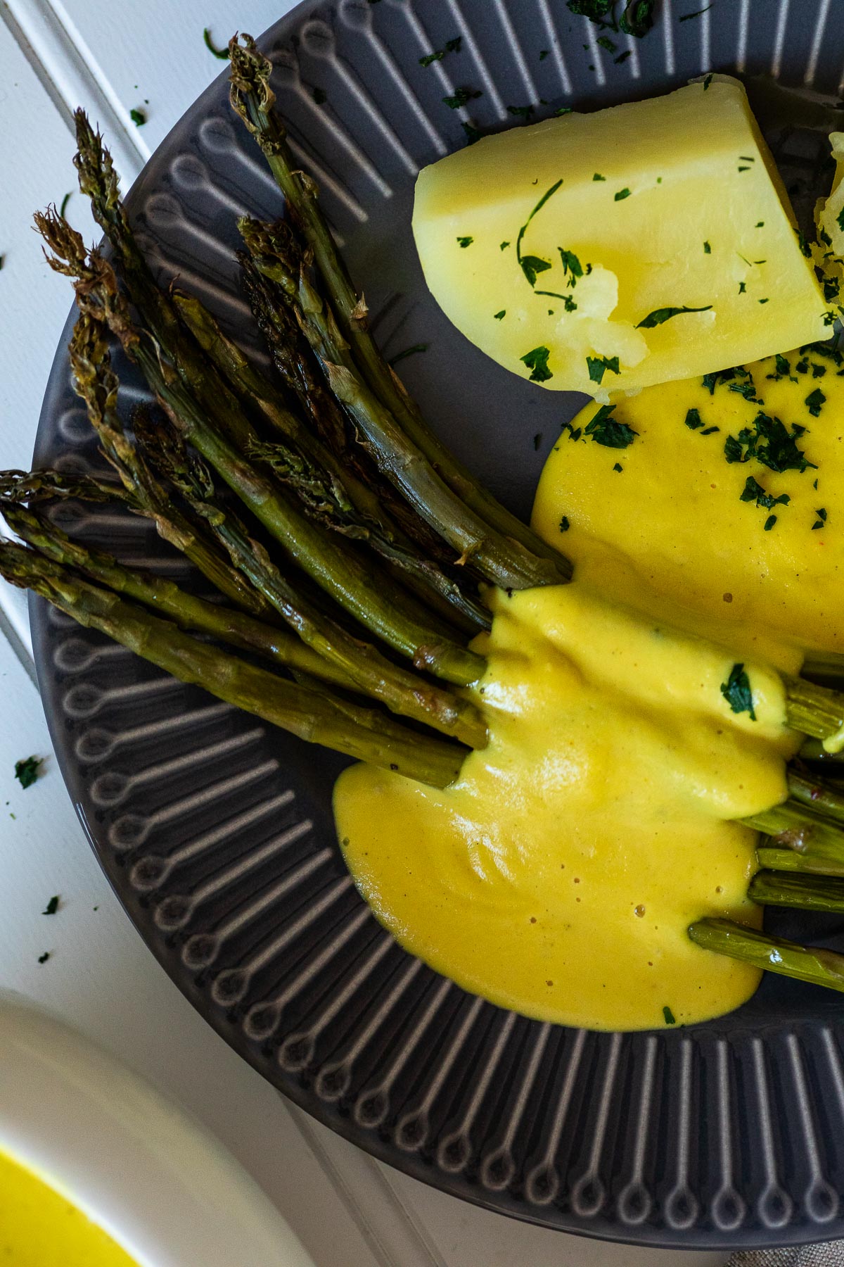 Nahaufnahme eines Tellers mit Spargel, Kartoffeln und Sauce Hollandaise