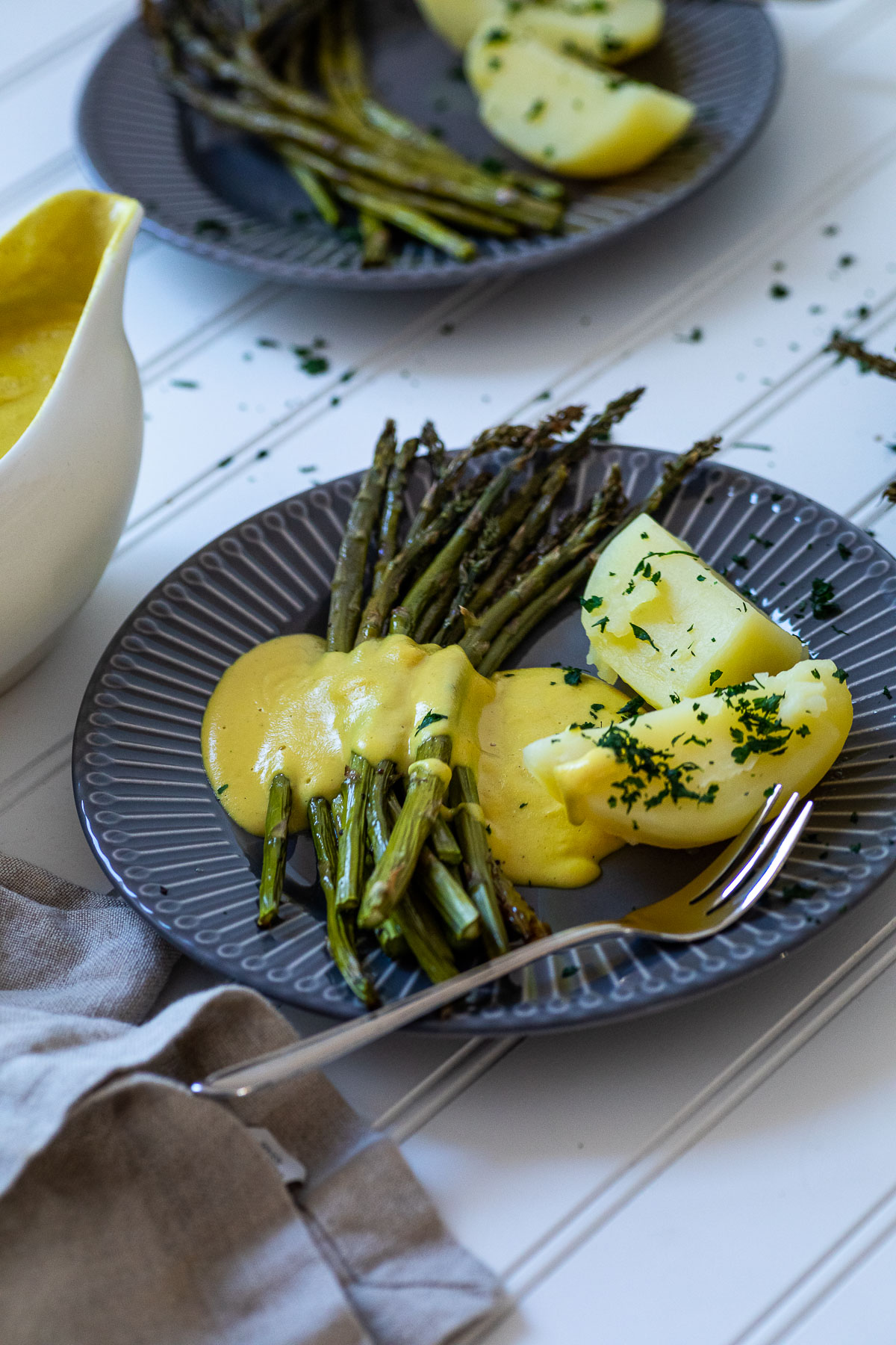 One Plate with Potatoes, Asparagus and dairy free hollandaise sauce with one plate in the background