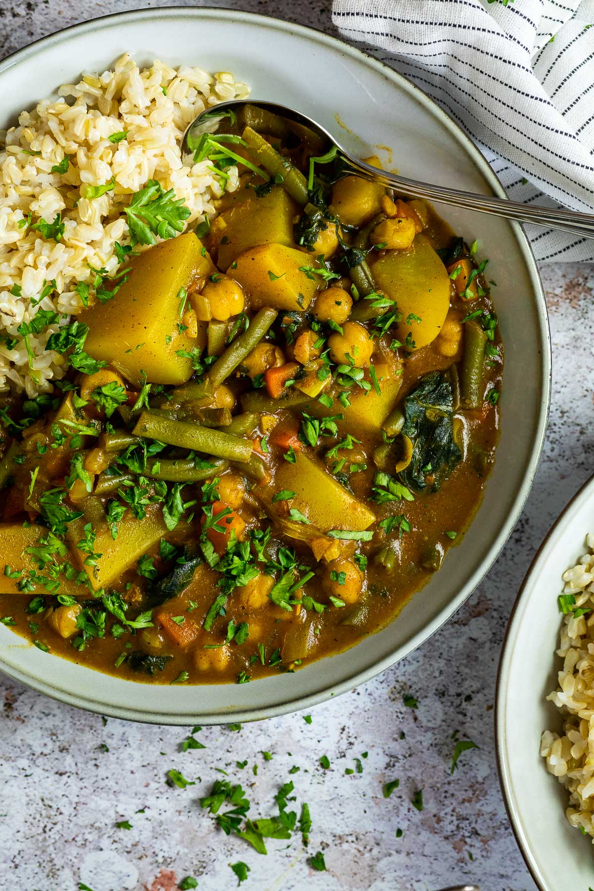 Schließen Sie oben von einem Teller mit Kartoffelcurry und Reis mit einem Tuch darüber