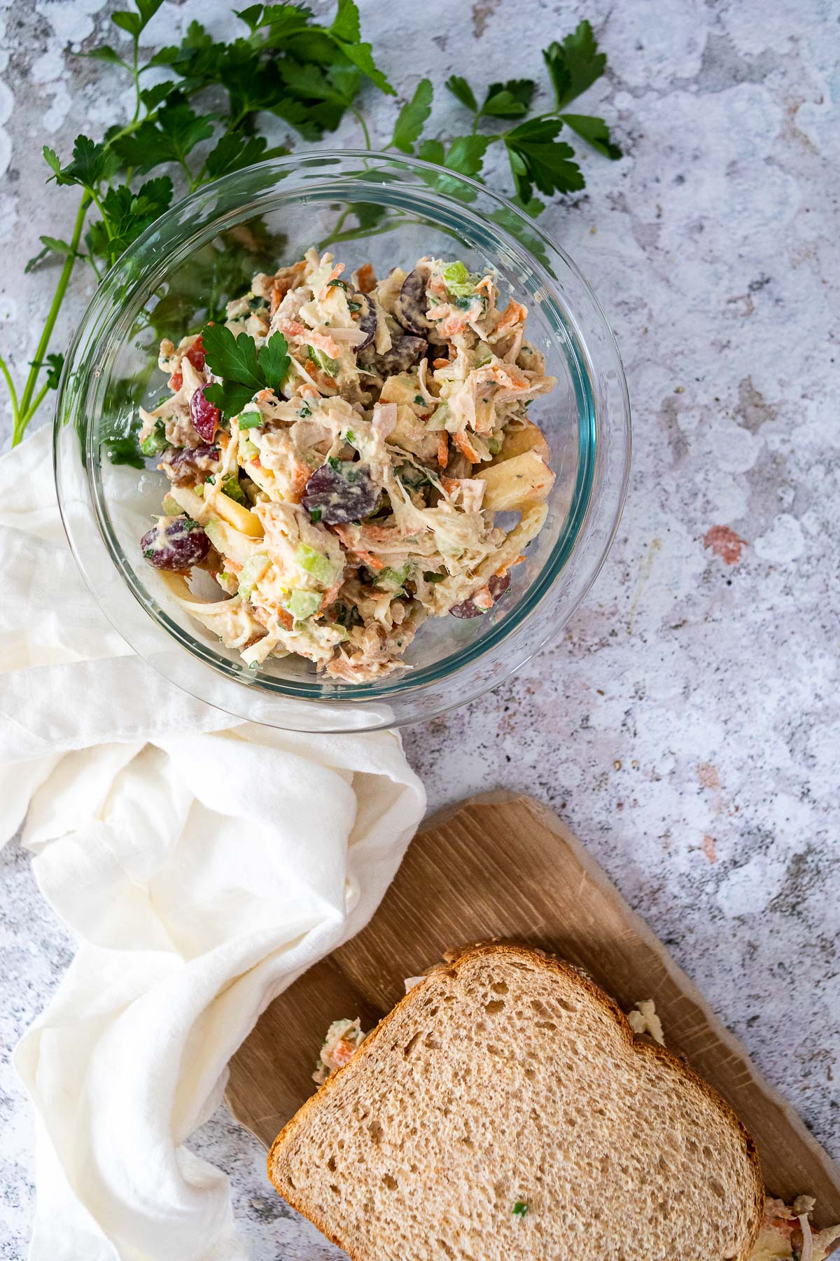 Bird's view of a shot with vegan chicken salad and a sandwich on a board