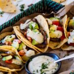 Potato tacos and garlic sauce bowls served on a tray