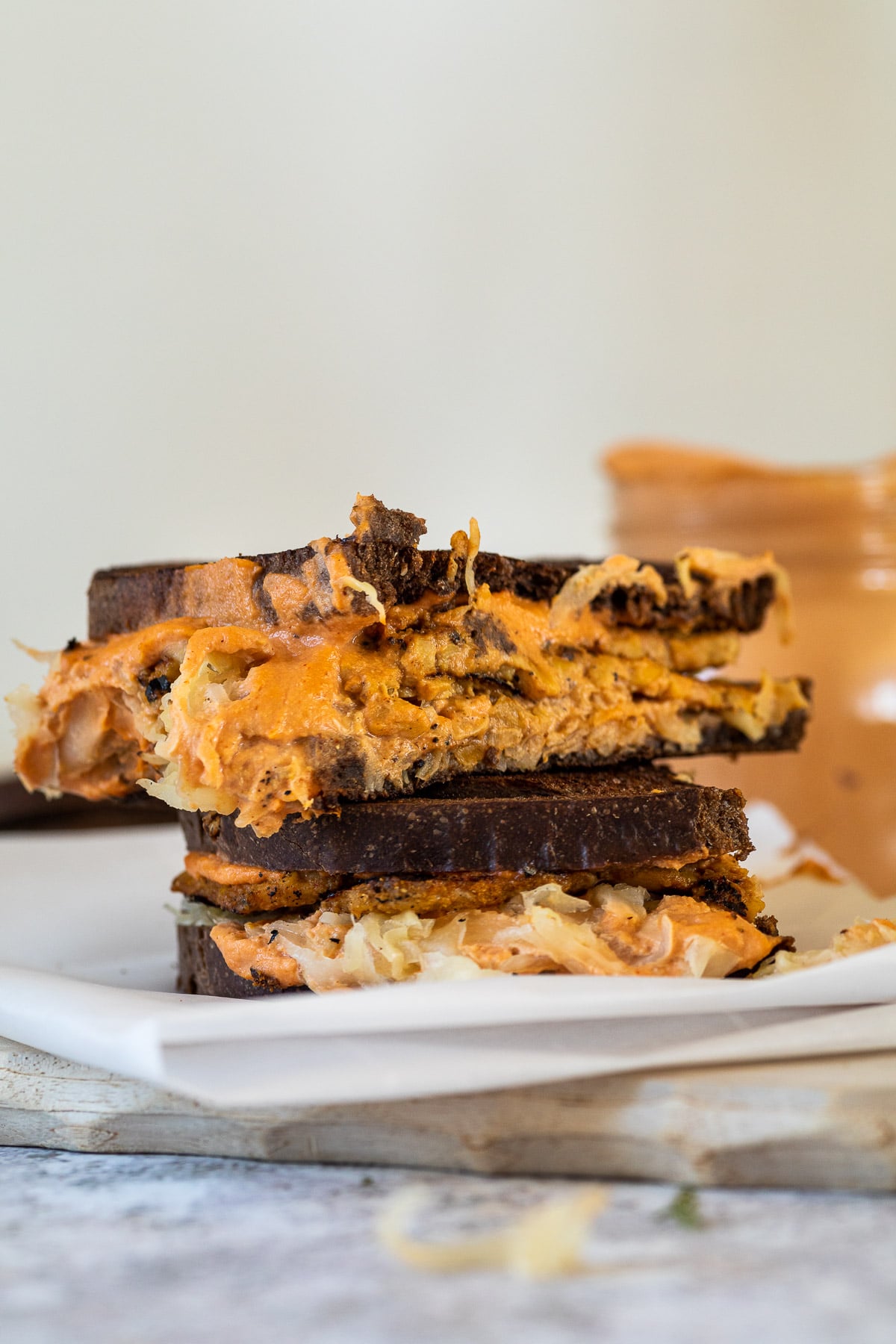 Two vegan Reuben sandwiches are lying on top of each other