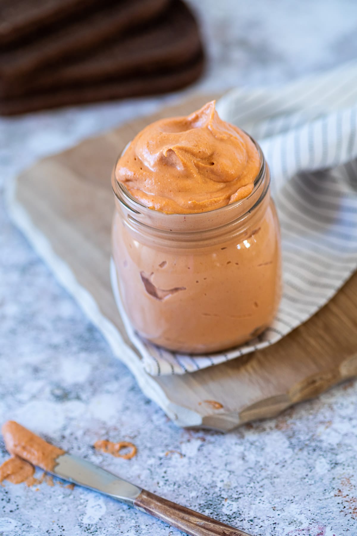 Veganes Russian Dressing in einem Glas auf einem Brettchen stehend