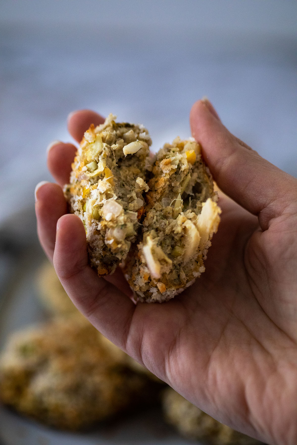 Holding one crab cakes halfed to show the vegan crab cake texture 