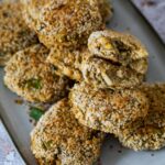 No Crab Cakes on a plate with one crab cake halfed to show the texture and inside