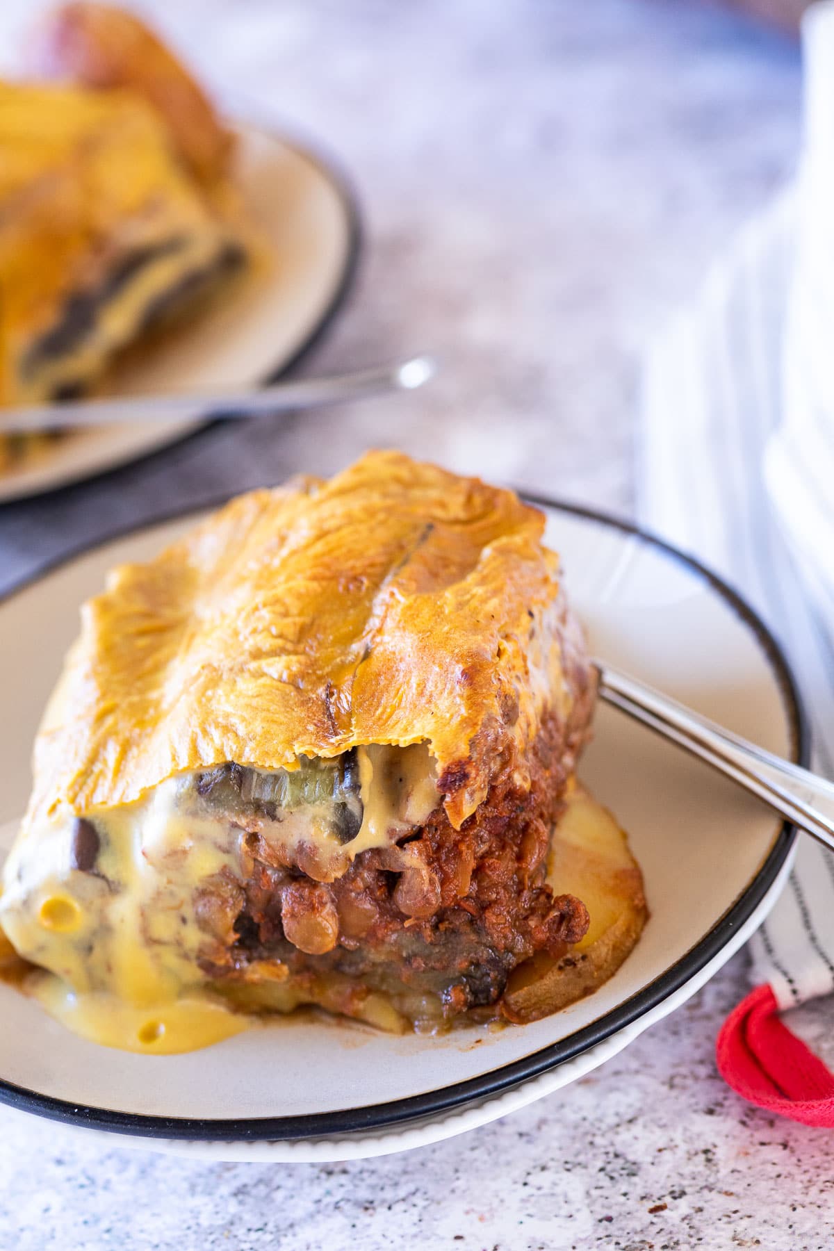 A Piece of vegan Moussaka on a plate with a fork