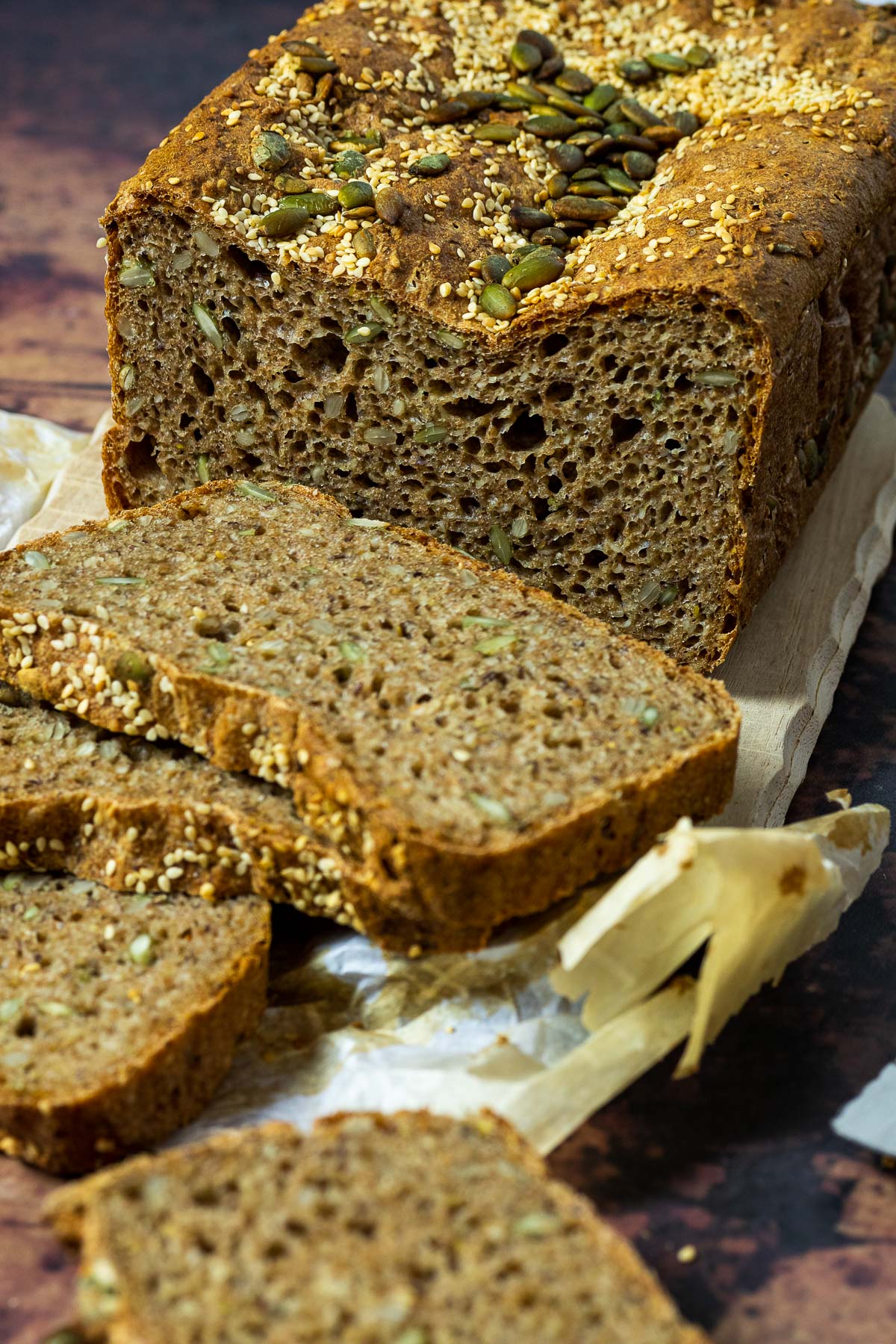 Spelt Bread topped with sesame seeds and pepita seeds cutted side in focus and some slices blurred in front