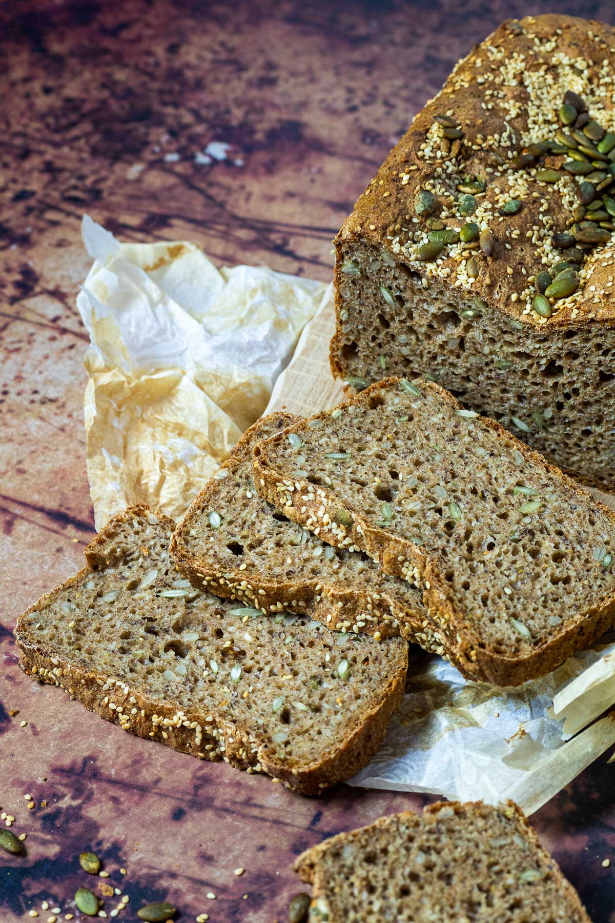 Artisan Spelt bread with 3 Slices in front of the half cutted spelt bread