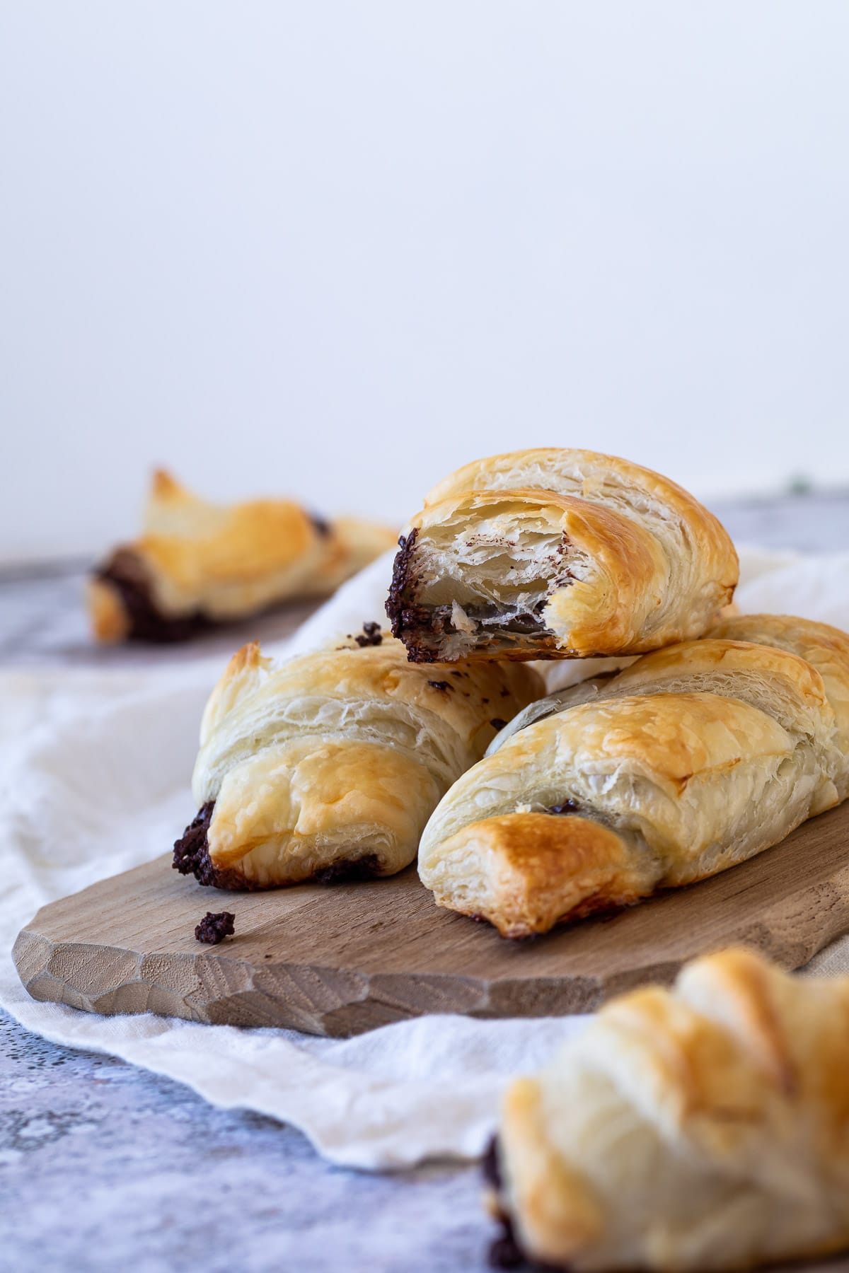 In focus a half chocolate croissants with flaky layers .