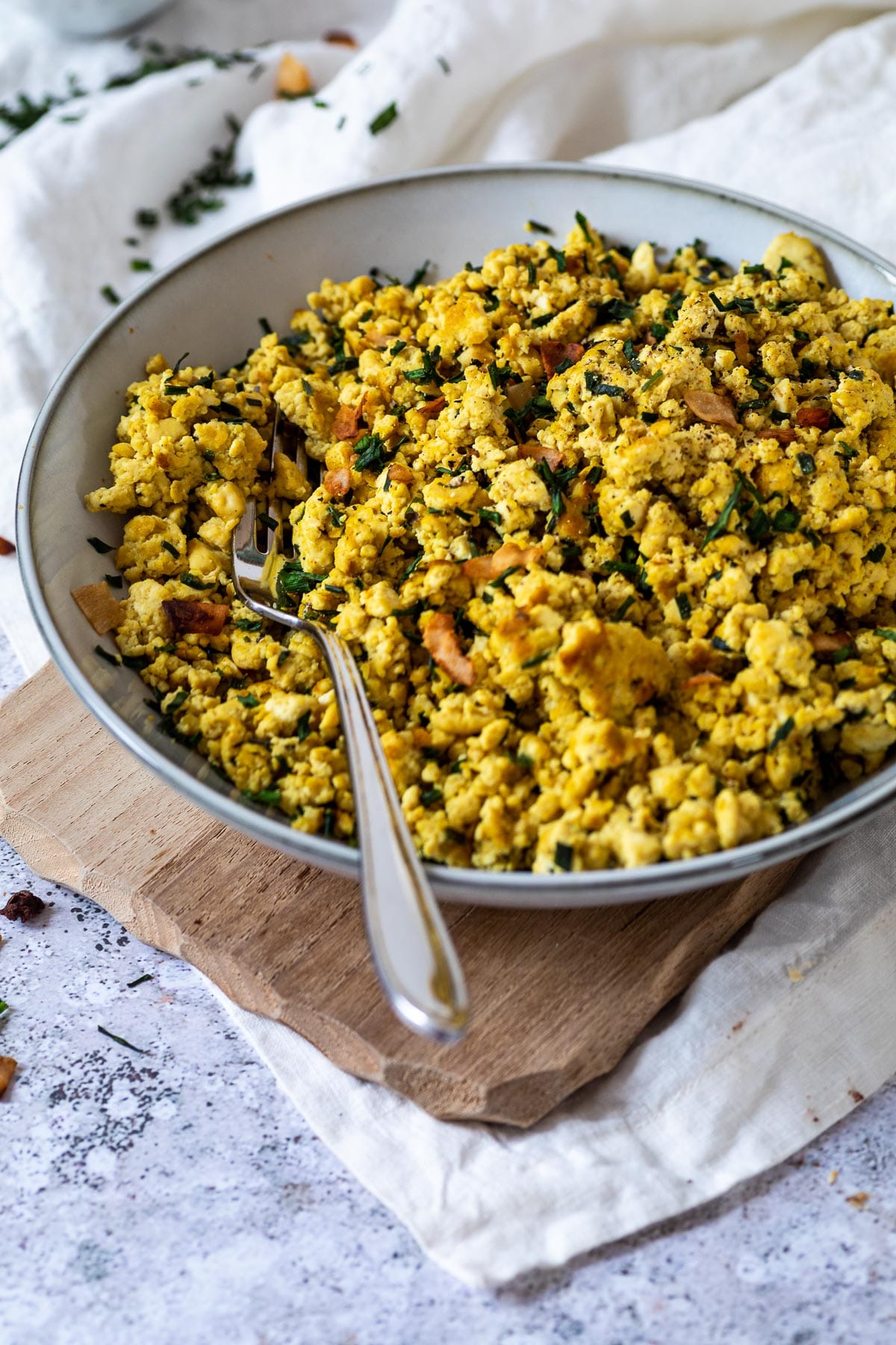 A bowl of vegan scrambled eggs with a fork