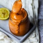 Holding a spoon with oil free vegan French Dressing over a jar french dressing