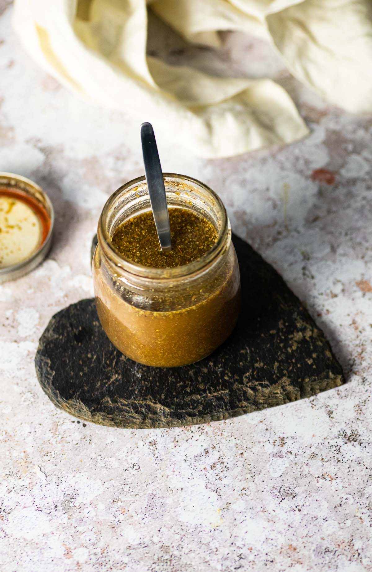 Ölfreies Balsamico-Dressing im Glas auf einer herzförmigen Steinplatte.