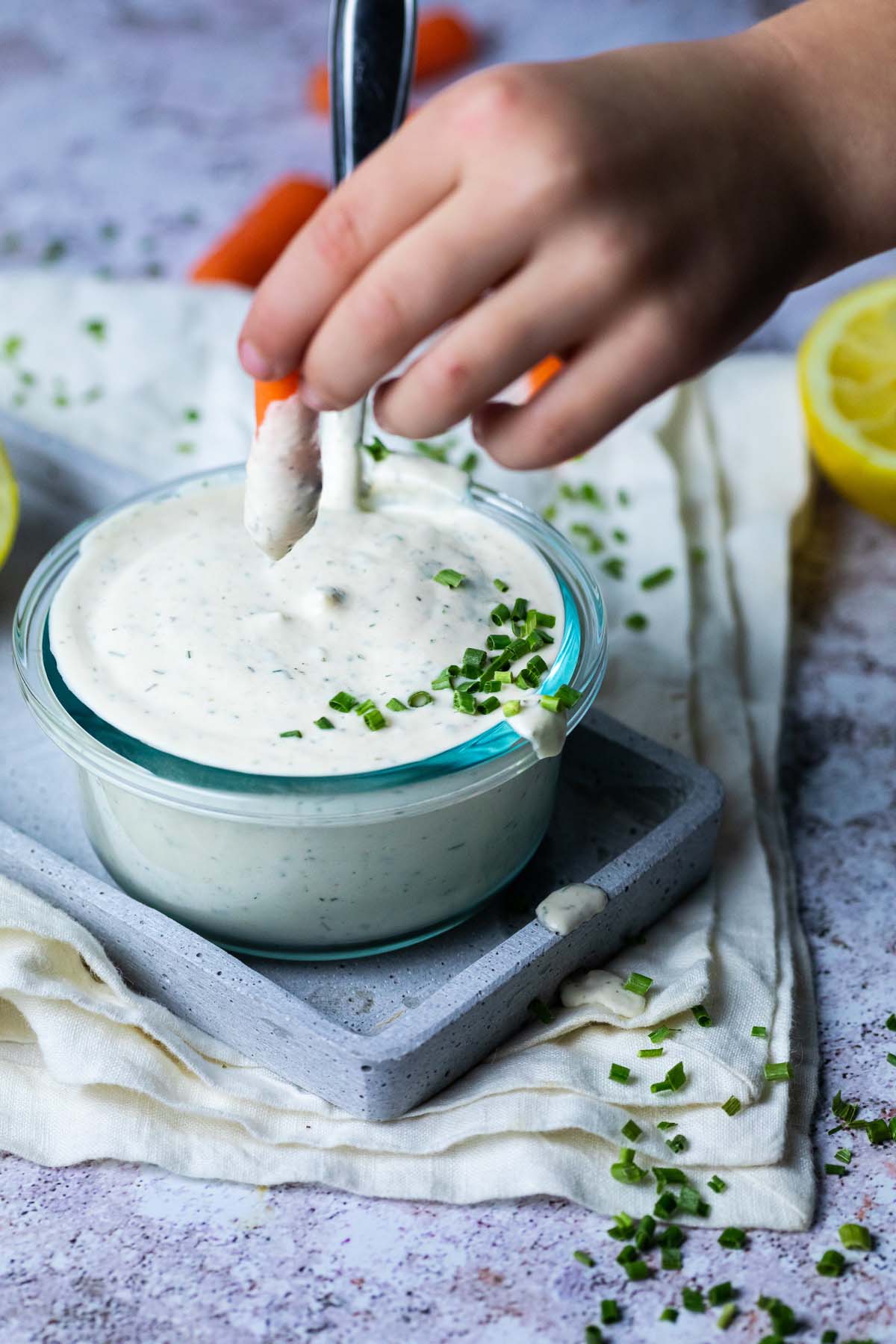 Dipping a carrot in vegan ranch dip